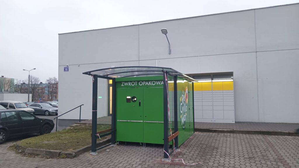 Zielony automat do zwrotu opakowań z napisem „Zwrot opakowań” przed sklepem w Polsce