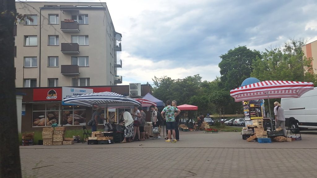 Stragany z warzywami i owocami na miejskim targu w słoneczny dzień